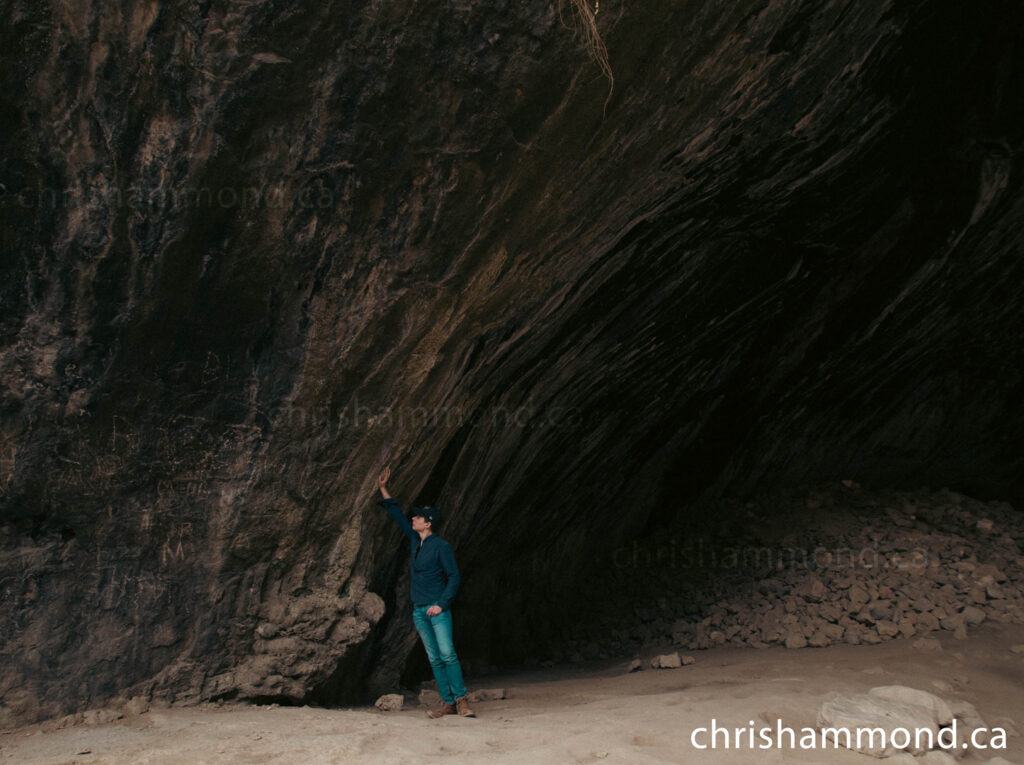 Photo of Chris placing his had on the eastern wall of Shanidar Cave as he takes a moment to imagine the life of the Shanidar neanderthals.